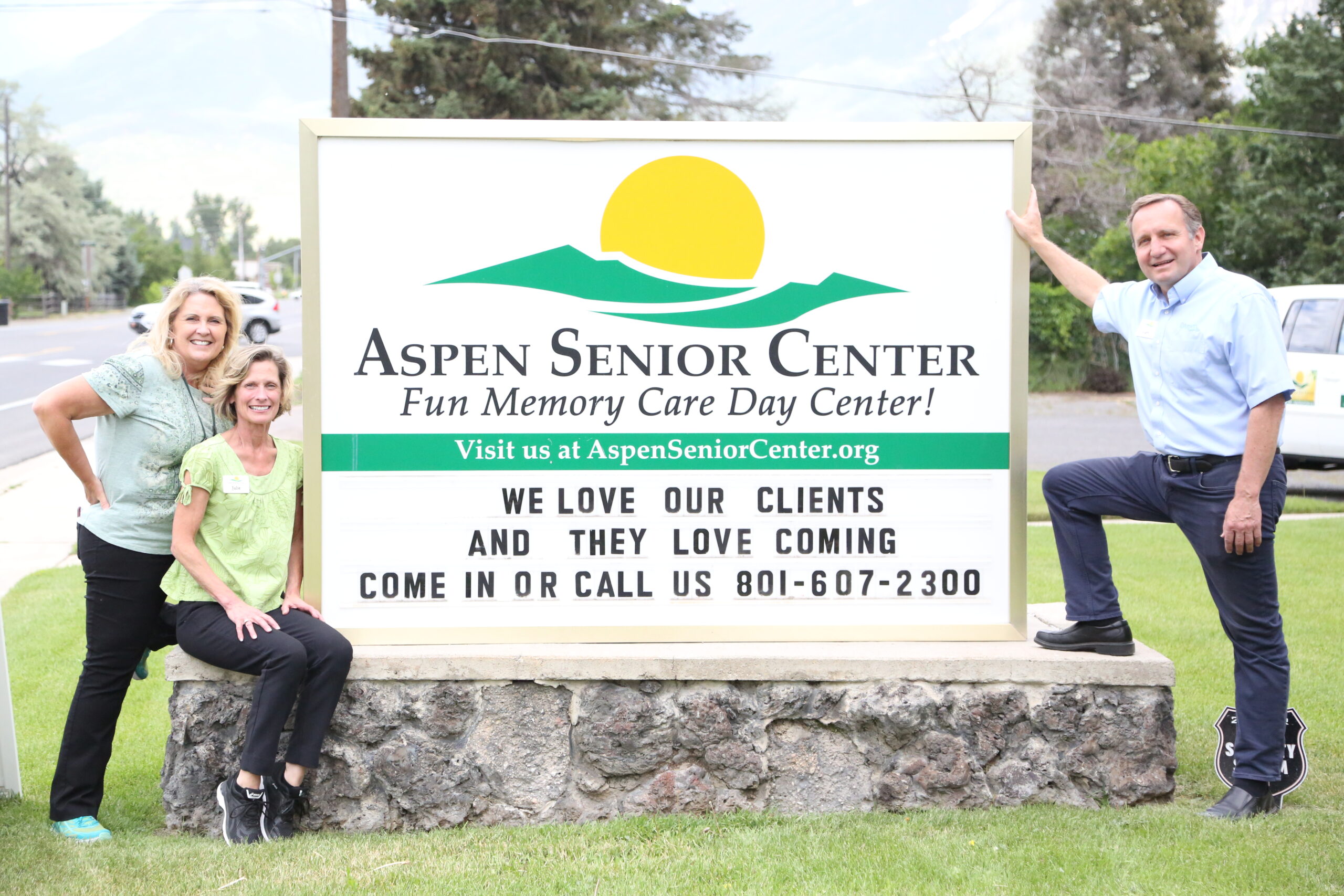 Gary, Julie, and Pam by the Aspen Senior Day Center sign.